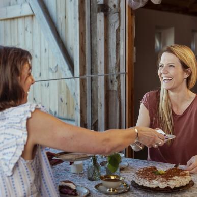To kvinder hygger og griner til Sønderjysk kaffebord på Klægager