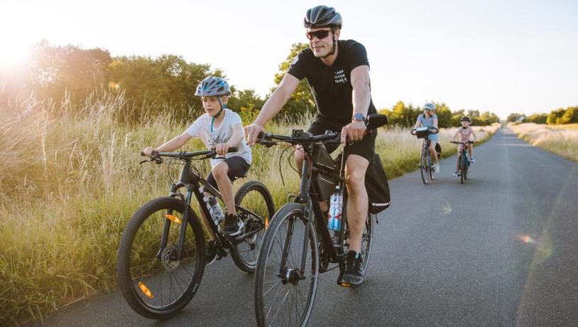 Cyklende familie på lang lige landevej på Kær Halvø