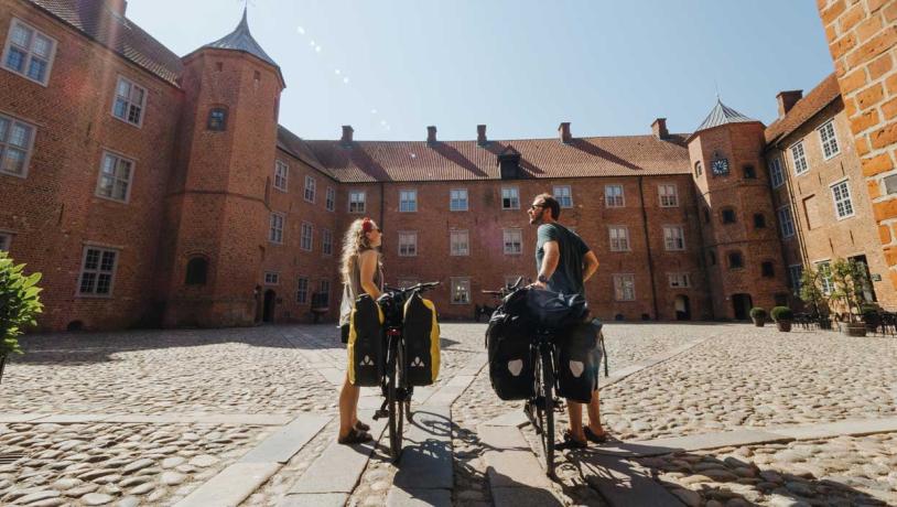 Par med cykler i gården ved Sønderborg Slot